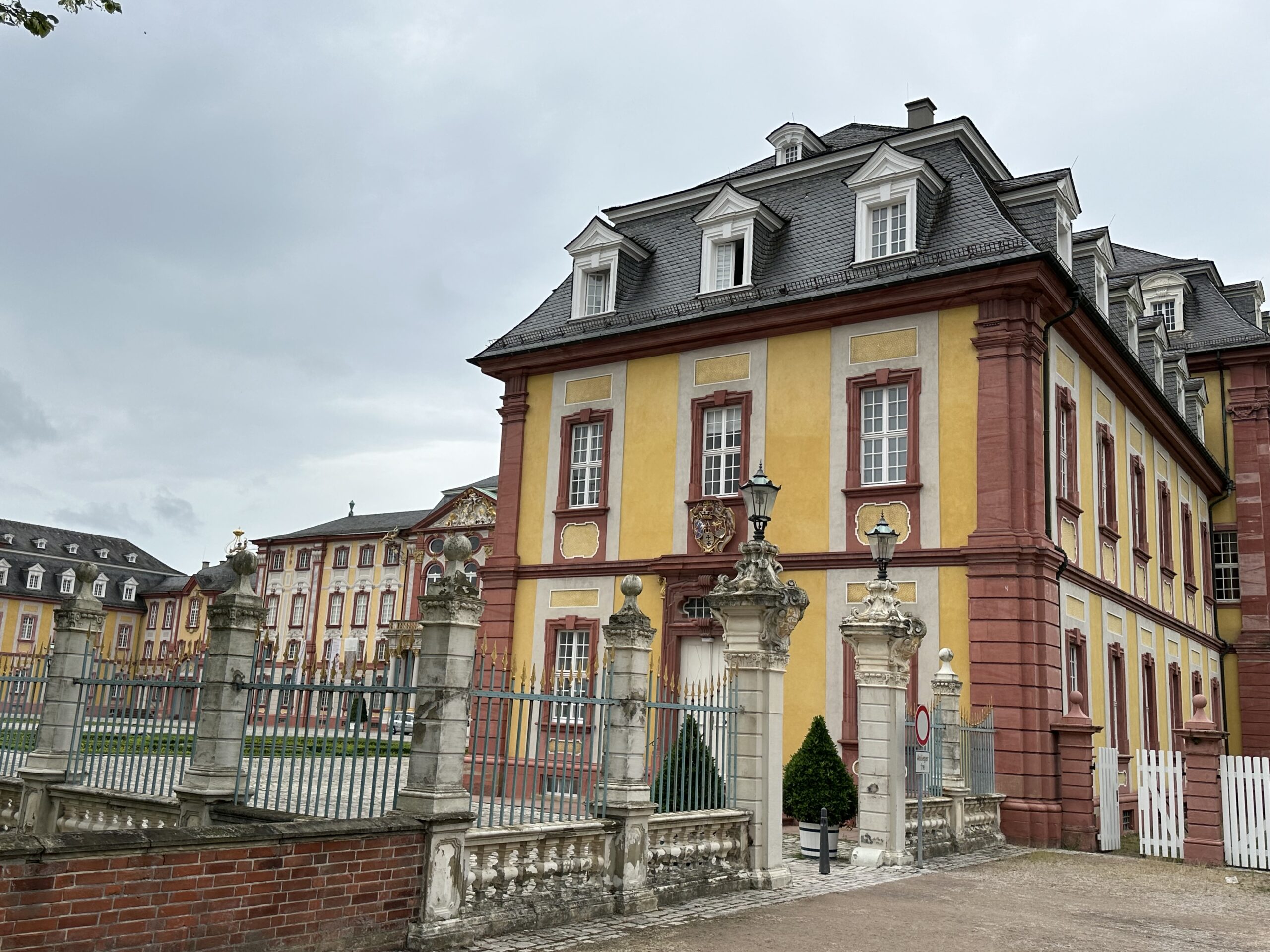 a yellow and red building with a fence and a gate